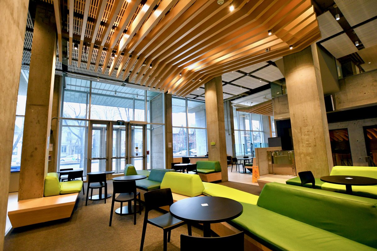 The 45 Willcocks Atrium lounge with tables, chairs, and couches spread in front of floor to ceiling windows.